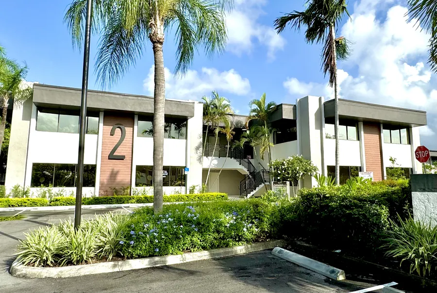 Exterior of Building 2 with palms and tropical planting