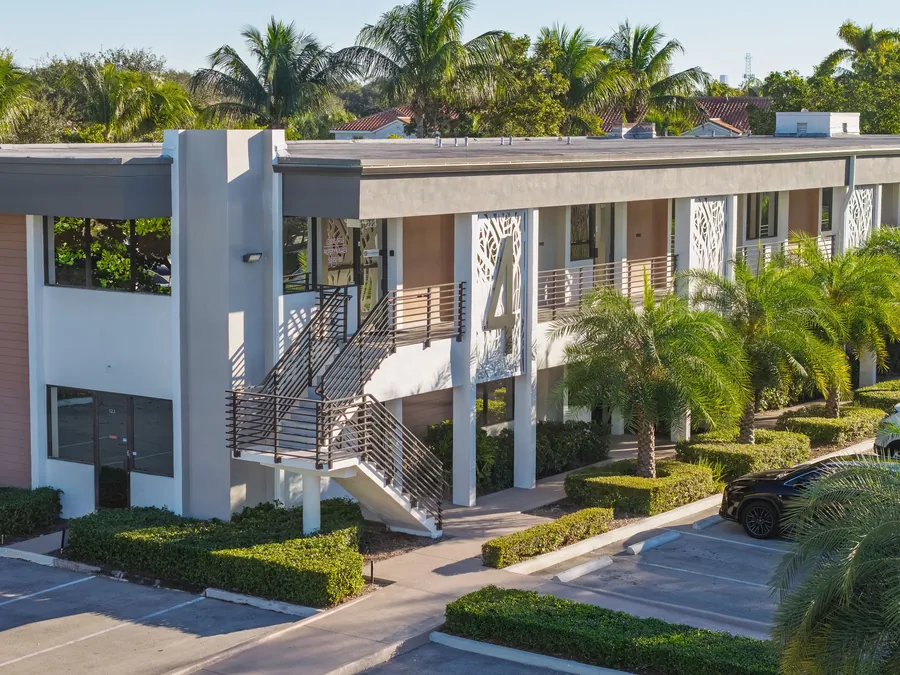 Aerial view of a two-story office building framed by palms